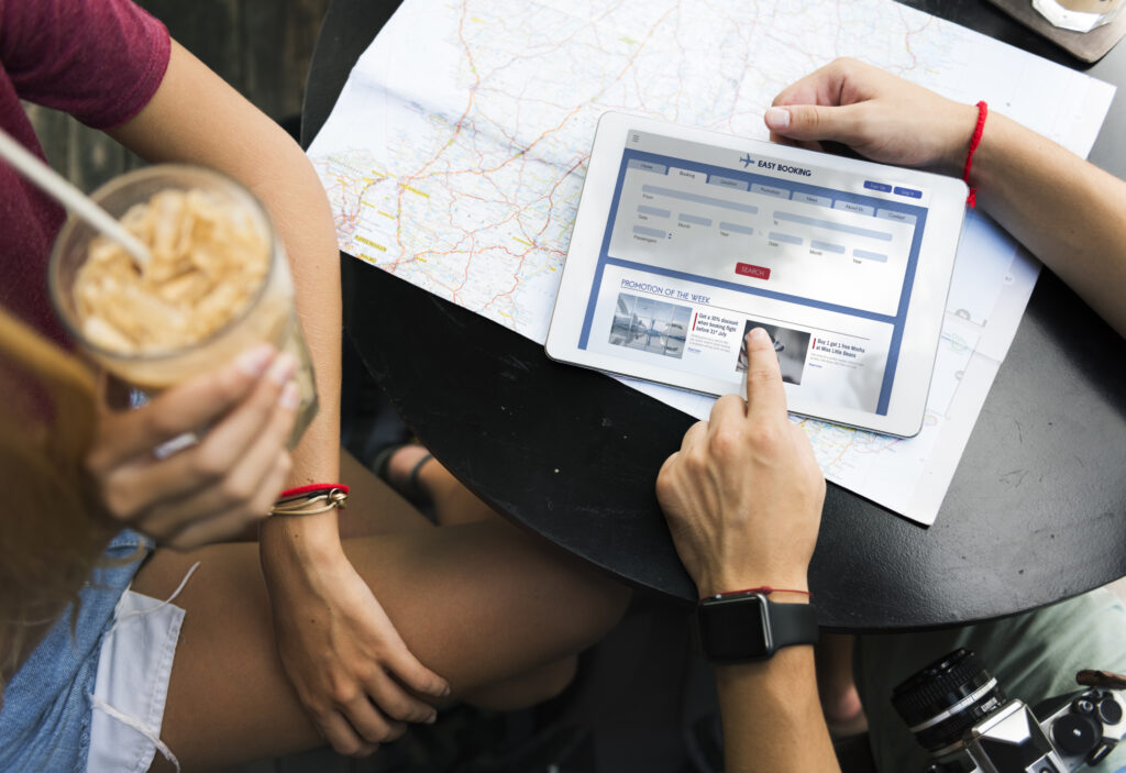 Voyageurs consultant une carte et un comparateur de voyage en ligne