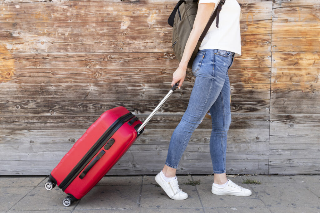 Bagage cabine dimension — guide complet 2025 par compagnie : valise cabine rouge tirée par une voyageuse