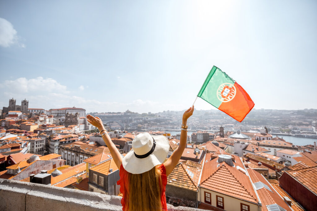 Vue sur Porto avec femme brandissant le drapeau du Portugal, voyage en famille 2025