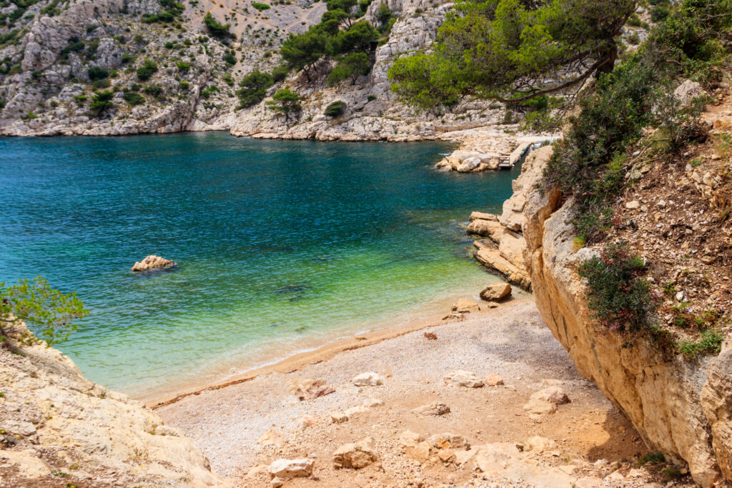 Calanque de Marseille avec eau turquoise, falaises et plage de galets, destination nature incontournable