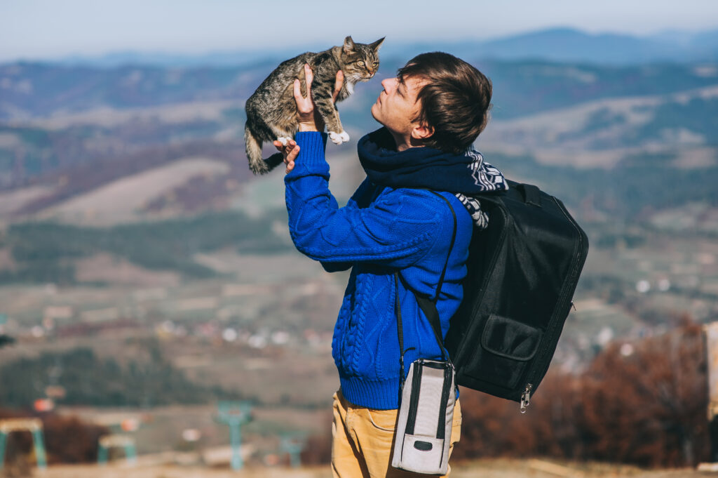 Voyageur tenant son chat en plein air – conseils pratiques pour voyager avec son chat