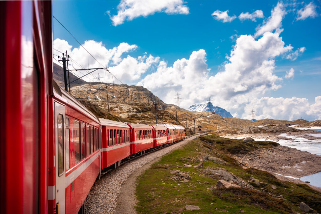 Train rouge Interrail traversant les montagnes en Europe – voyage pas cher 2025