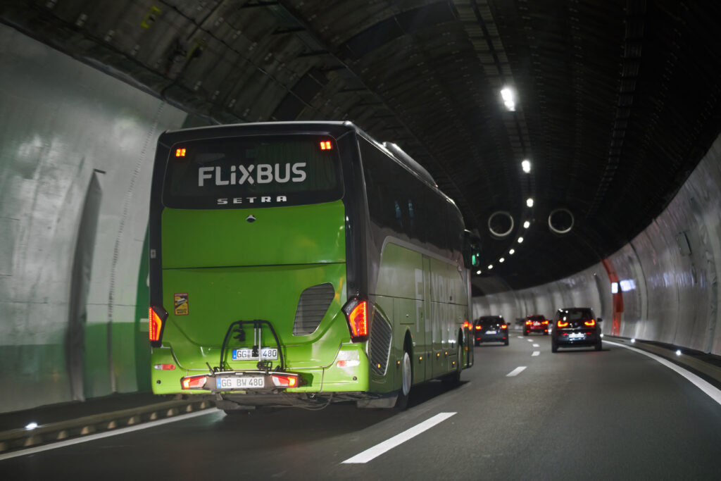 Bus FlixBus vert traversant un tunnel en Europe, symbole des voyages low cost.