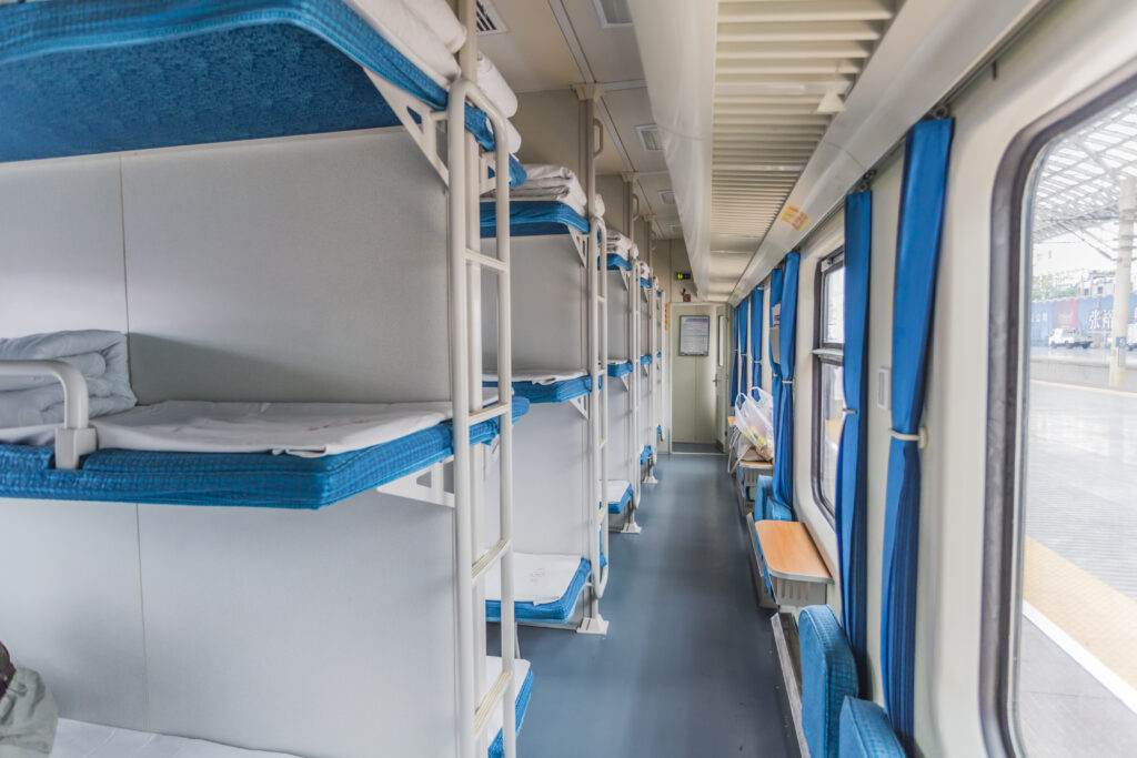 Compartiment de train de nuit en Europe avec couchettes bleues – voyage pas cher et pratique.