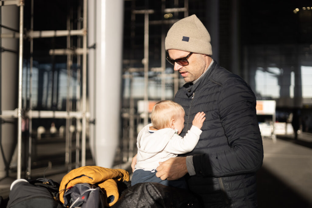 Voyager avec bébé low-cost : poussette cabine, lits et laits — parent avec bébé à l’aéroport
