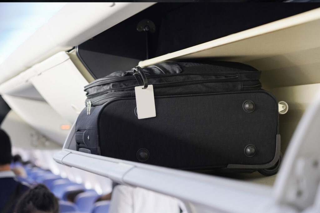 Bagage cabine only : tailles & check-list (Ryanair, Vueling) — valise cabine dans le compartiment supérieur