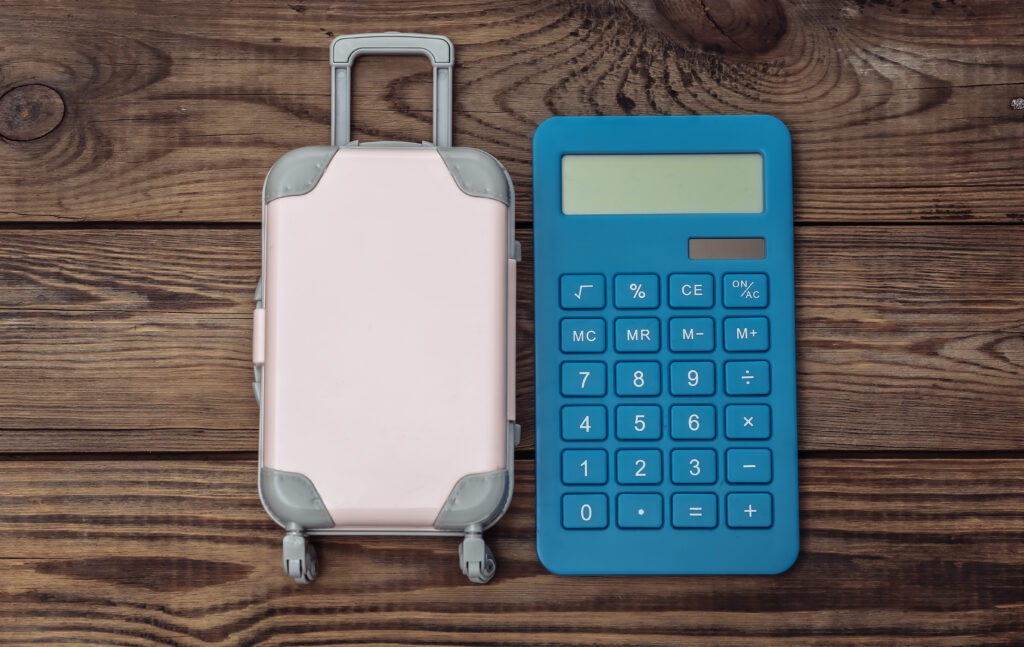 Calculette Mauricette — simuler votre budget voyage en ligne : valise et calculatrice sur table en bois