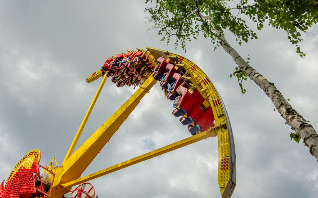 Parc attraction Espagne — grande roue/atttraction jaune avec passagers, ciel bleu
